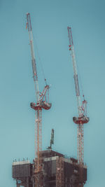 Low angle of construction cranes on building