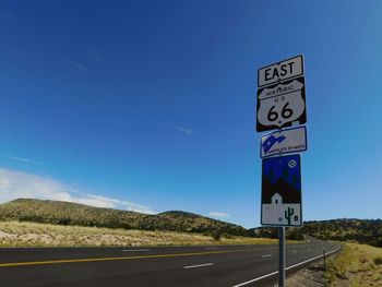 Road sign against clear blue sky