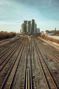 Railroad tracks in city against sky