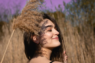 Close-up of smiling young woman by plants