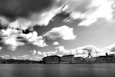 Buildings in city against cloudy sky