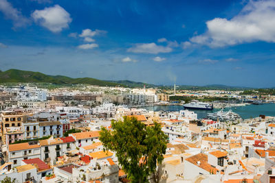 High angle view of town by sea against sky