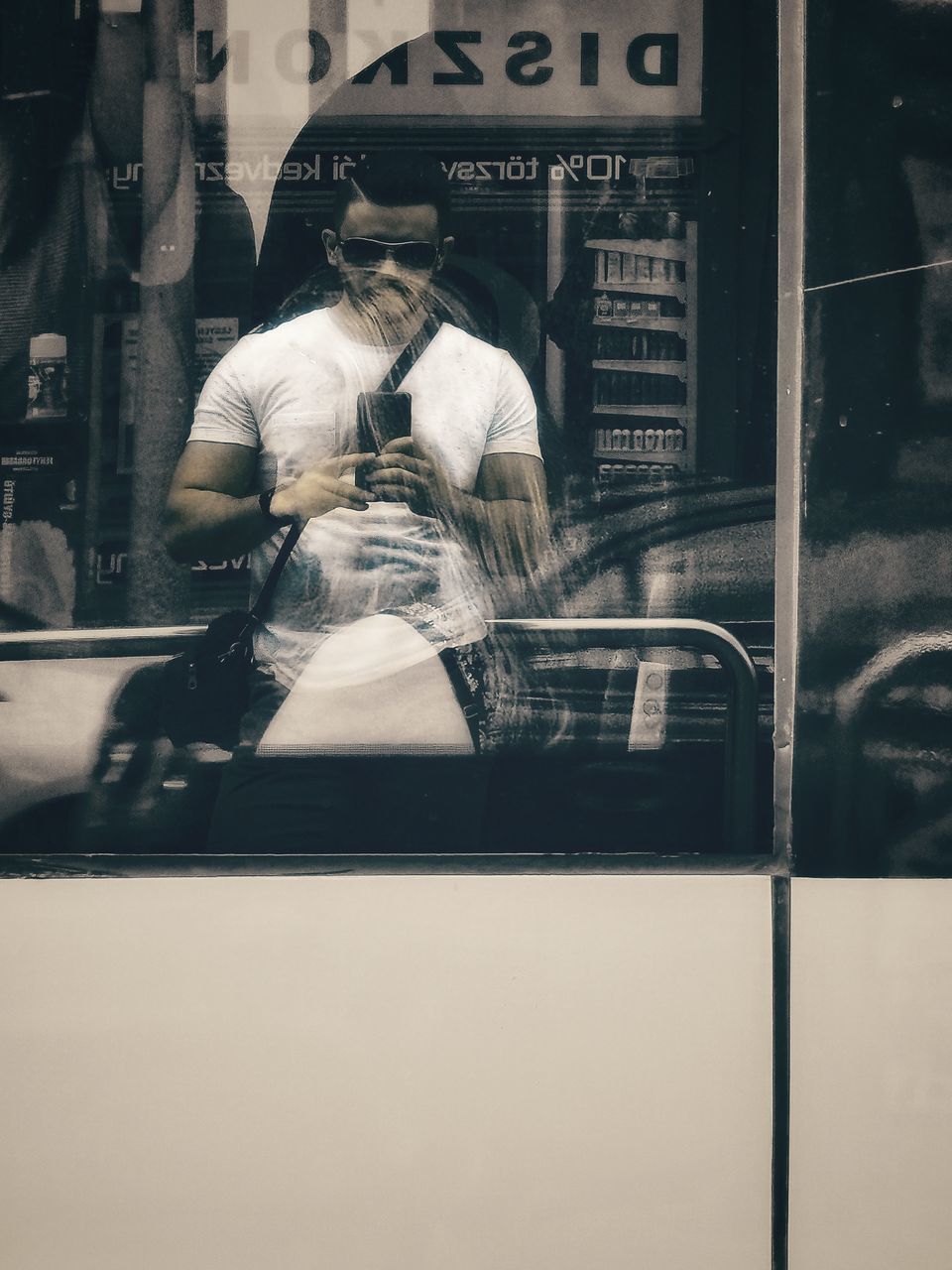 REAR VIEW OF MAN SEEN THROUGH WINDOW