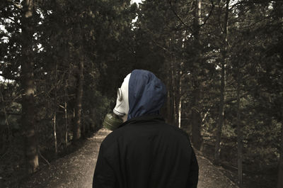 Rear view of man  with gas mask in forest