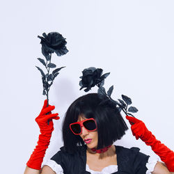 Elegant vampire gothic lady in red gloves holding black roses. role-playing games, halloween