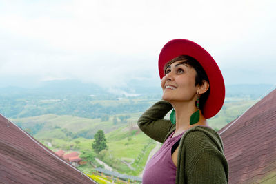 Portrait of young woman standing against mountain