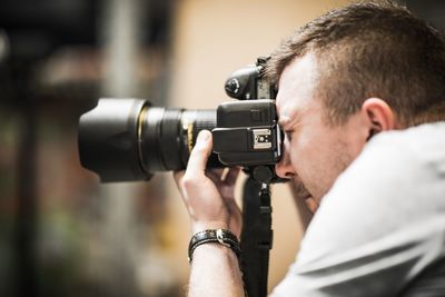 Close-up of man photographing with camera