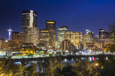 Illuminated buildings against sky at night