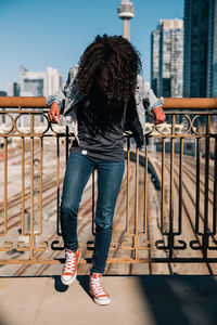 Low section of woman standing on railing