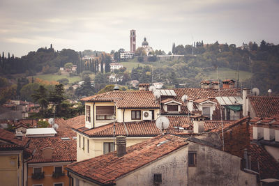 Houses by trees against sky