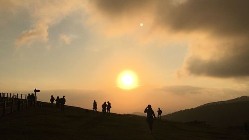 Silhouette people against sky during sunset