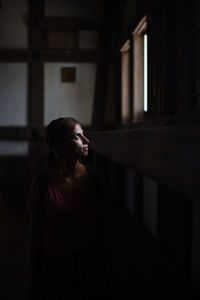 Woman looking up while standing in corridor