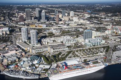 Aerial view of cruise ship and buildings in city on sunny day