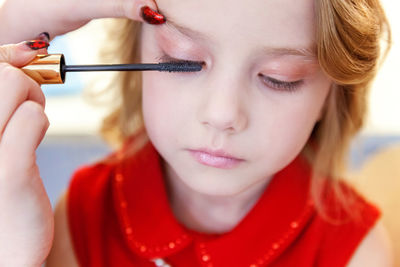 Close-up of young woman applying nail polish