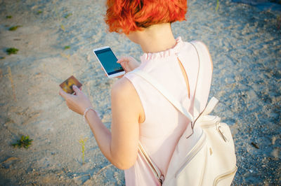 Rear view of young woman using mobile phone