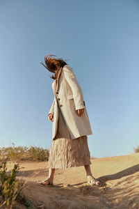 Portrait of woman standing against clear sky