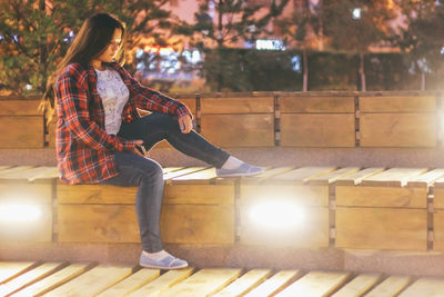 Full length of woman sitting outdoors