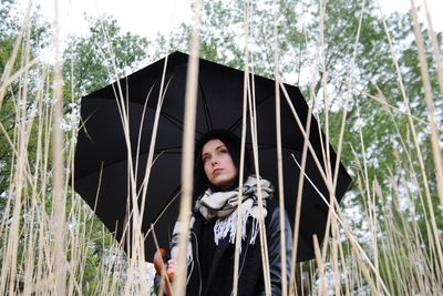 Portrait of teenage girl standing against plants