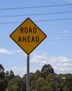 Low angle view of road sign against sky