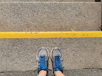 Low section of person standing on road