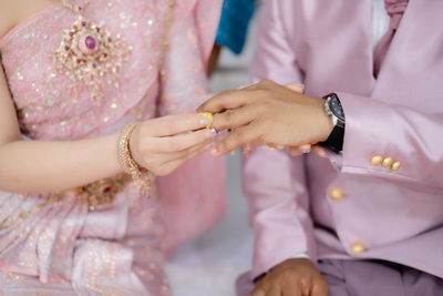 Midsection of bride holding wedding dress