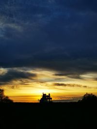 Scenic view of silhouette field against sky during sunset