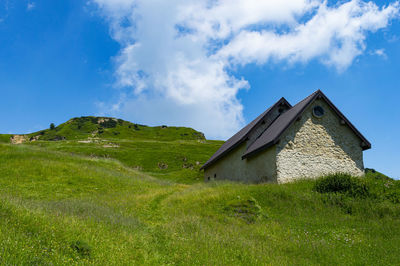 Low angle view of building on field against sky