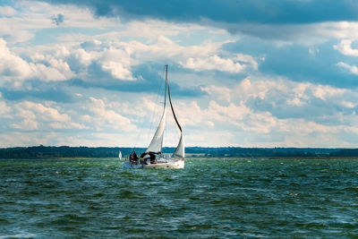 Sailboat sailing on sea against sky