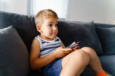 Boy sitting on sofa at home