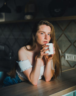 Portrait of young woman drinking coffee