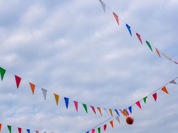 Low angle view of flags against sky