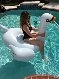 High angle view of women on inflatable raft in swimming pool