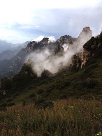 Scenic view of mountains against cloudy sky