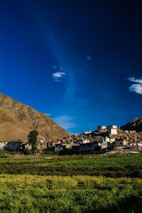 Houses on field against blue sky at night