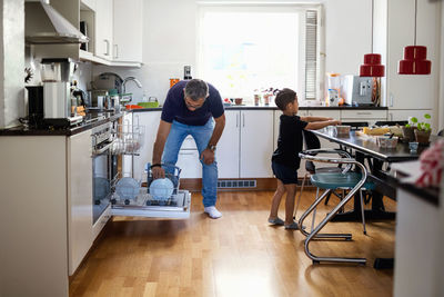 Father and son working in kitchen at home