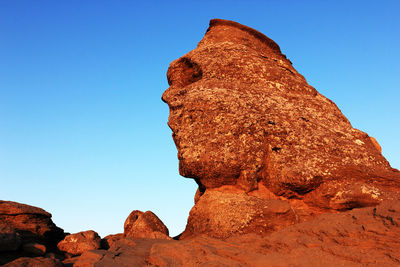 Sphinx rock formation against clear blue sky at bucegi natural park