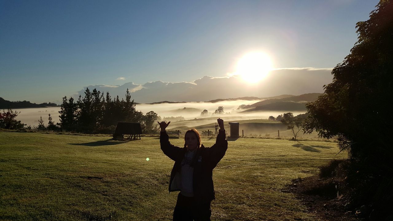 sun, sky, grass, sunlight, leisure activity, tranquility, tranquil scene, lifestyles, scenics, beauty in nature, field, water, nature, sunbeam, beach, lens flare, standing, landscape