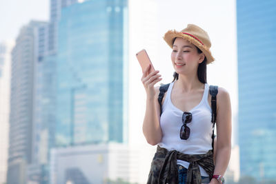 Smiling young woman using smart phone