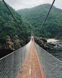 View of footbridge leading towards mountains