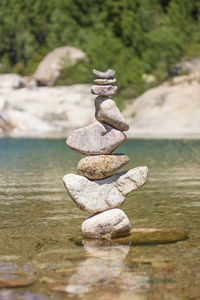 Stack of pebbles on rock in sea