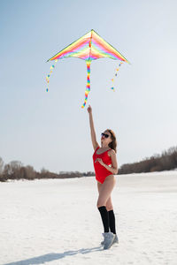 Rear view of woman standing on snow covered field