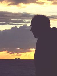 Silhouette woman standing by sea against sky during sunset