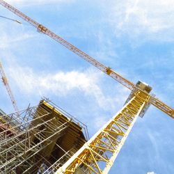 Low angle view of crane against sky