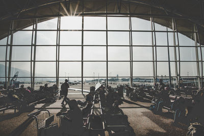 Group of people on glass window at airport