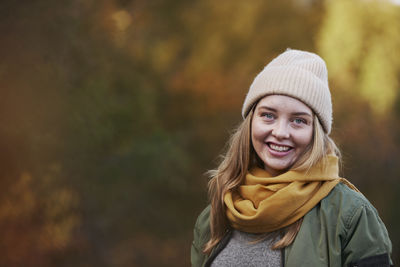 Portrait of young woman in warm clothing standing outdoors