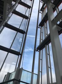 Low angle view of glass building against sky