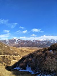 Scenic view of mountains against blue sky