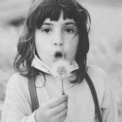 Portrait of cute girl holding dandelion flower