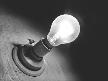 Close-up of illuminated light bulb on table