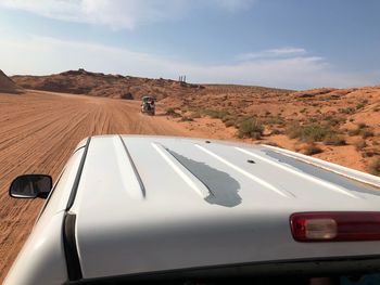 Reflection of man on car moving on road